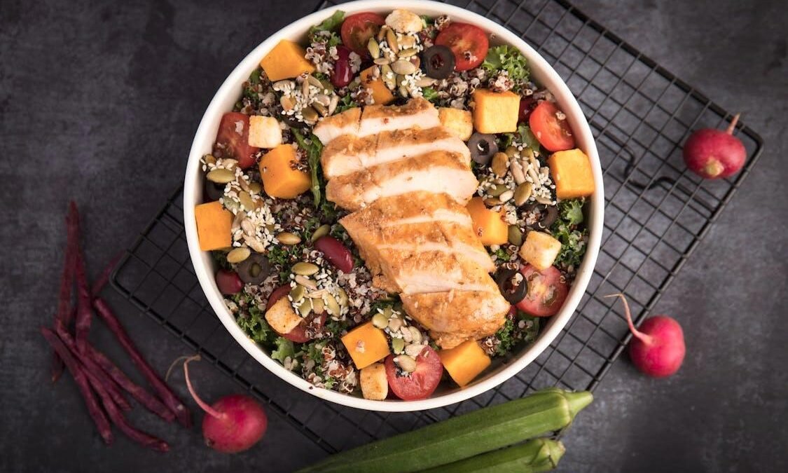 Fresh grilled chicken with quinoa and vegetables served on a plate