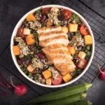 Fresh grilled chicken with quinoa and vegetables served on a plate