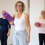 An image of women holding yoga mats for a group workout class