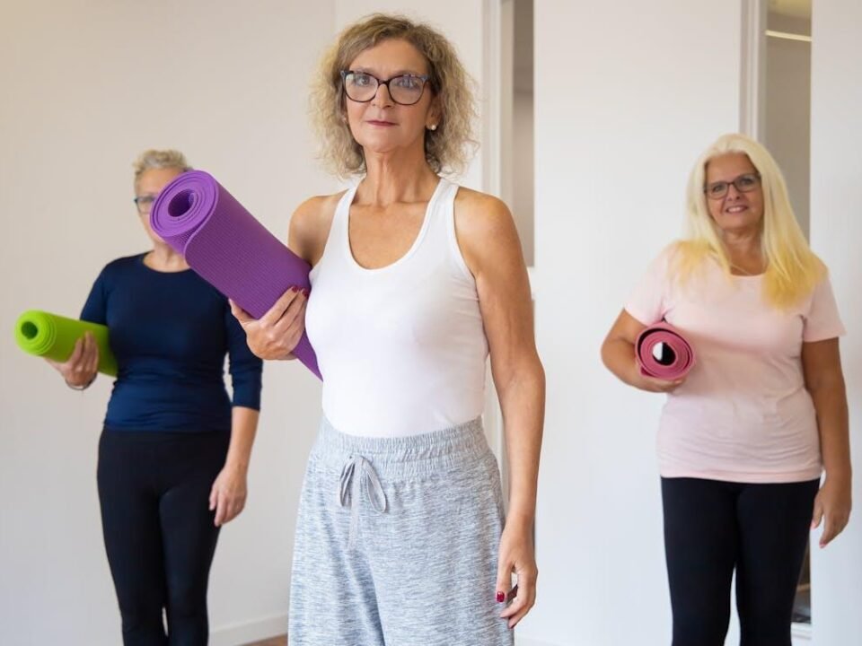 An image of women holding yoga mats for a group workout class