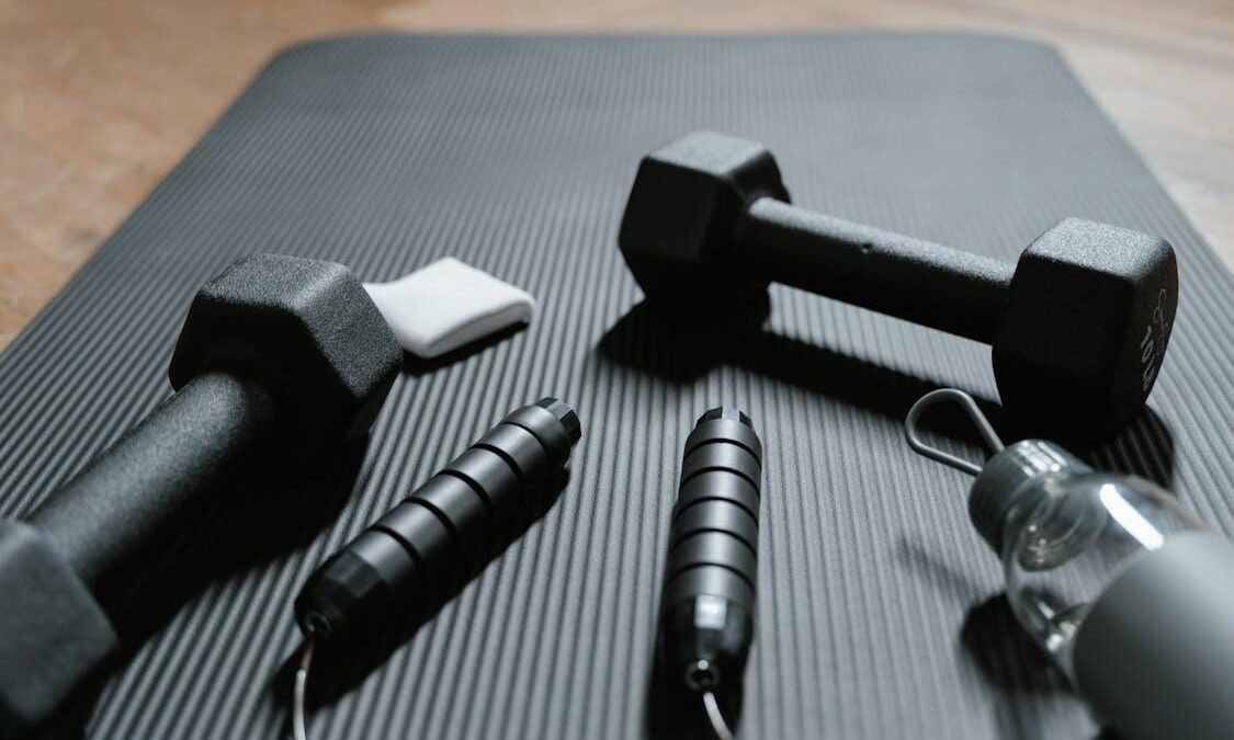 Dumbbells and a Jumping Rope on a Yoga Mat