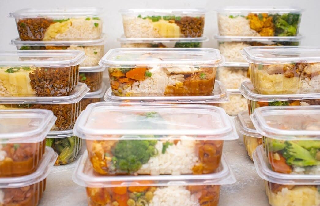 Multiple meal prep containers with rice, vegetables, and protein prepared for the week