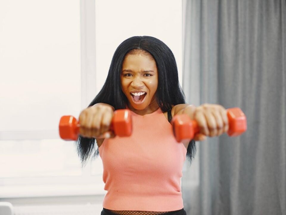 Woman performing dumbbell exercise at home, focusing on upper body strength training